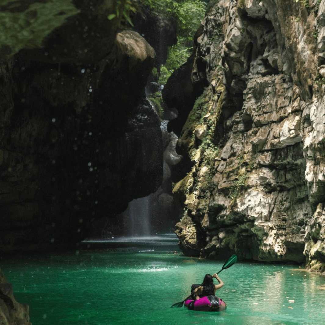 tango fiberglass bent shaft kayak paddle green tide being paddled through rock formations #color_green-tide