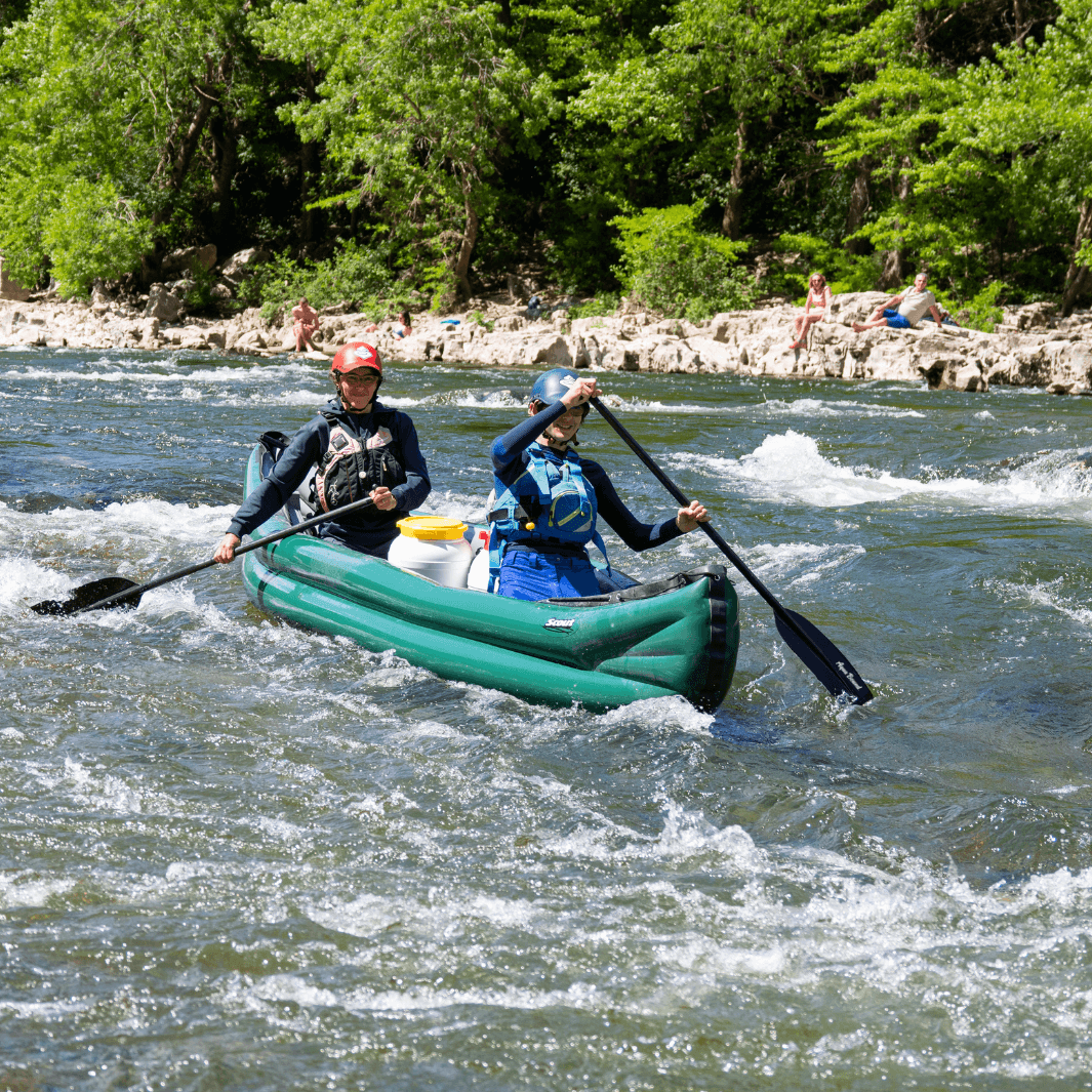 2 whitewater canoeists using the edge 2-piece carbon canoe paddle through small rapids