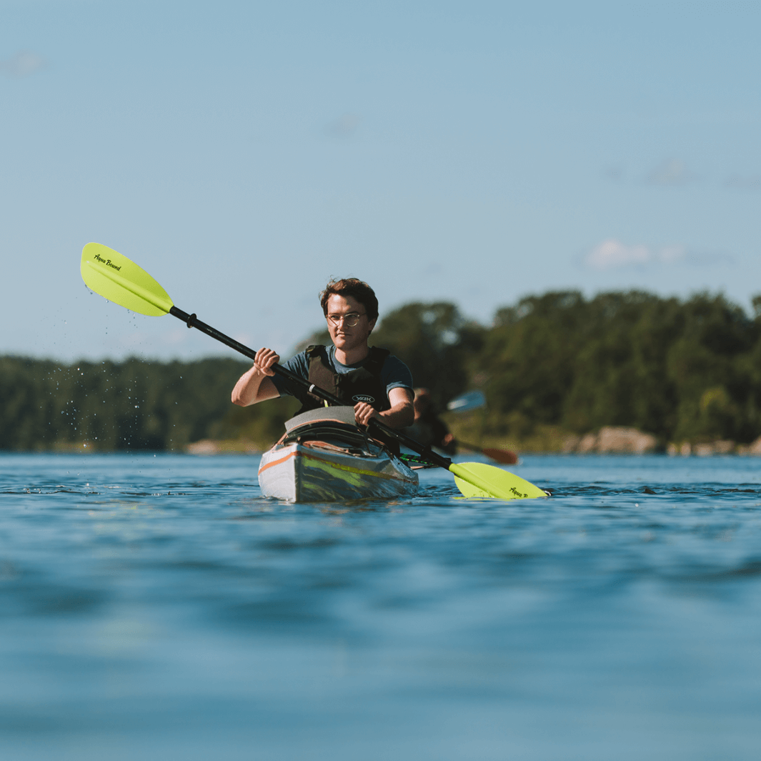 sting ray fiberglass 4-piece snap button electric green being paddled by young man in glasses#color_electric-green