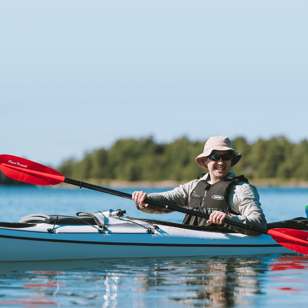 sting ray fiberglass 4-piece snap button sunset red being paddled by man smiling with bucket hat#color_sunset-red